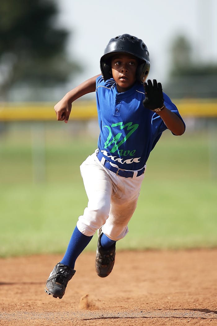 A child sprints energetically across the baseball field, showcasing agility in the sport.
